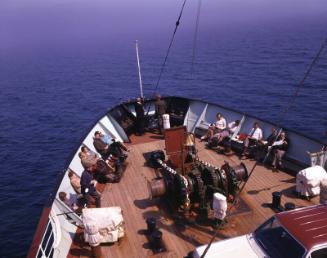 Foredeck of St Ninian (II) with various passengers seated and a car on the deck