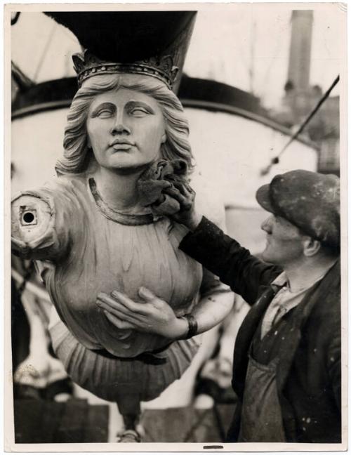 Black and white photograph showing the figurehead of the St Sunniva (II) being dusted