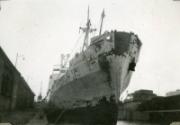 Black and White Photograph in album of ship 'Aberdonian Coast' being repainted at dockside