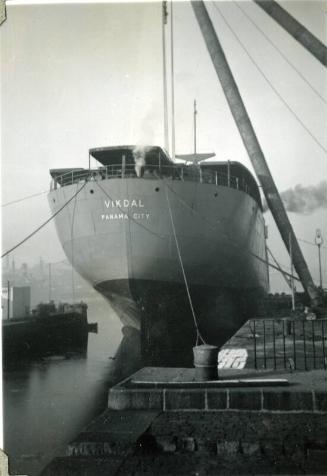 Black and White Photograph in album of 'Vikdal' stern tied up alongside Hall Russell's shipyard