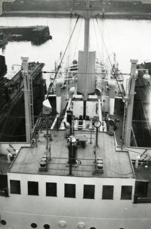 Black and White Photograph in album of 'Borre' under tow in harbour