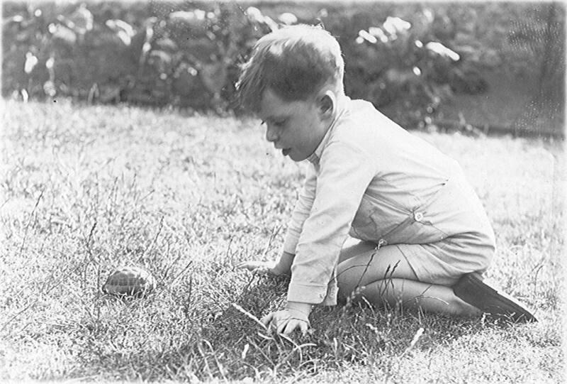 Boy A.T.Mackay with tortoise in garden