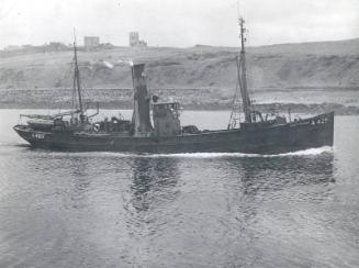 Black and white photograph showing the Trawler A420 'Jean Stephen' entering harbour, view of st…