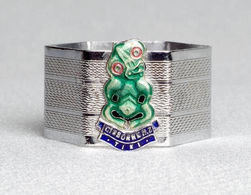 Hexagonal chrome napkin ring with enamel crest