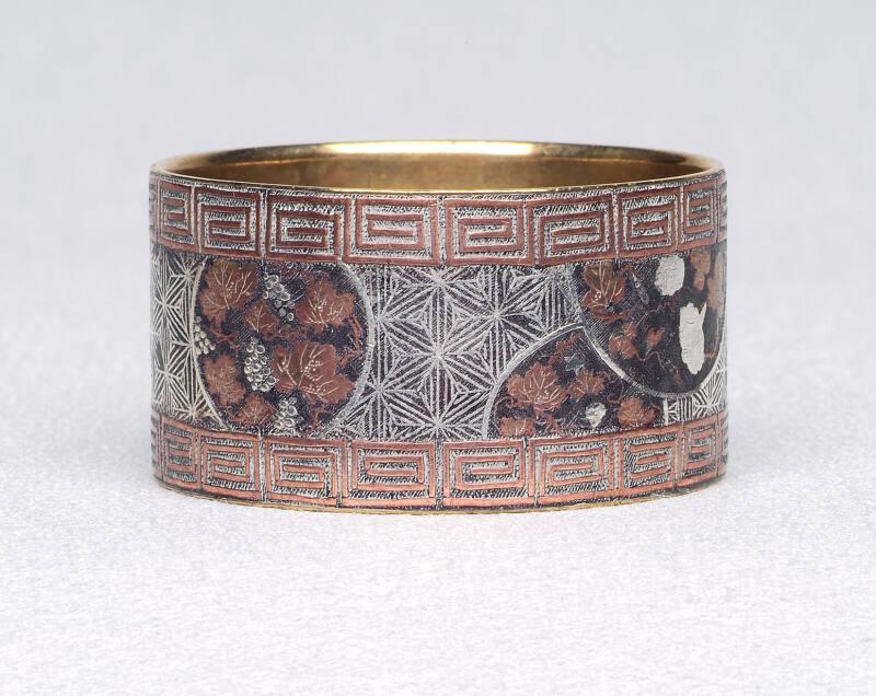 Inlaid napkin ring with greek key and vine pattern