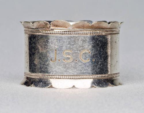 Silver plated napkin ring with scalloped edges.