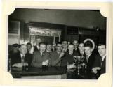 Black and white photograph Of Group At Bar With A Trophy. Possibly A Hall Russell Football/Bowl…