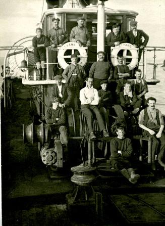 Black and white photograph of crew in front of wheelhouse