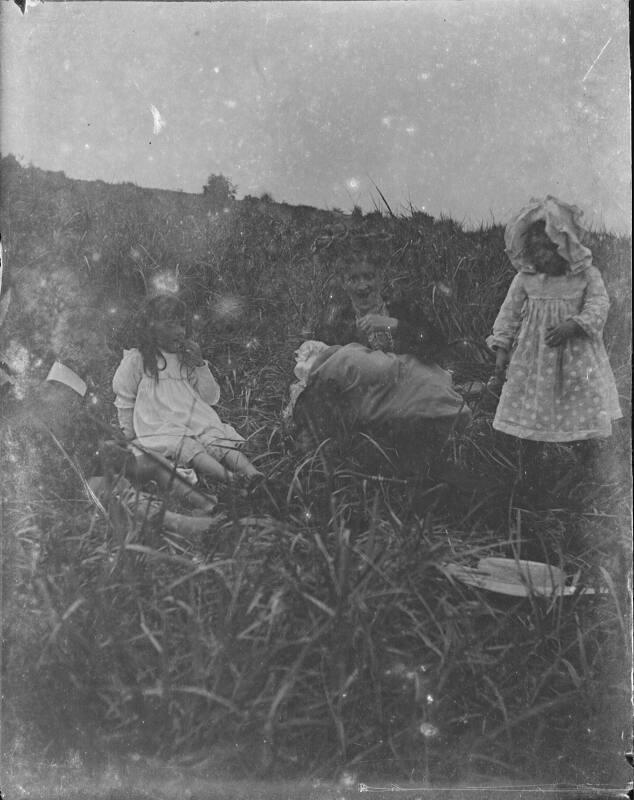 Children with adult in grass bank.