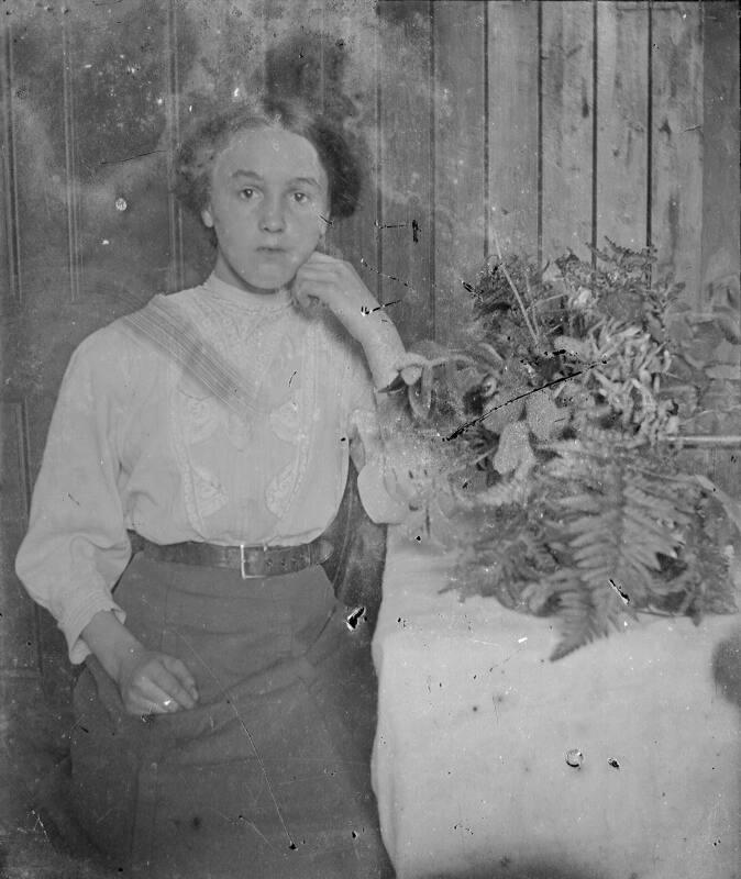 Young women seated by floral display indoors