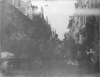 View down street with decorated buildings, unidentified celebration.