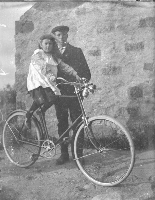 Man holding Bicyle with Seated Child