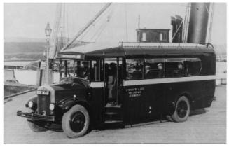 photograph taken at Warehouse Pier, Stromness, with special bus in foreground and parts of 'St …