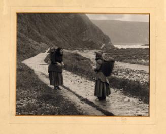 b/w photograph of two fishwives meeting at the shore
