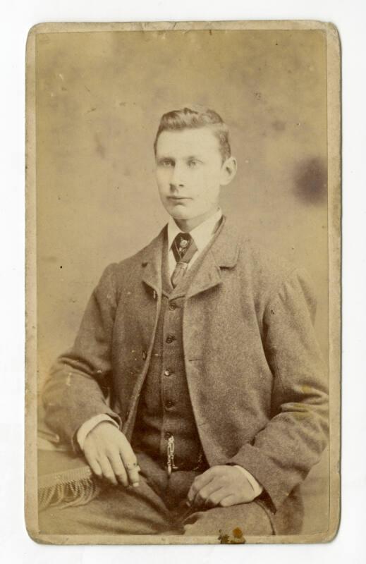 Young man, seated, in tweed suit