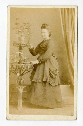 Standing young woman with high twisted plait