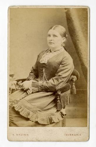 Young woman seated on velvet chair