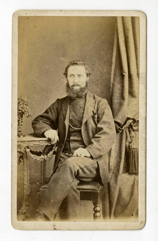 Seated bearded man with high double breasted waistcoat