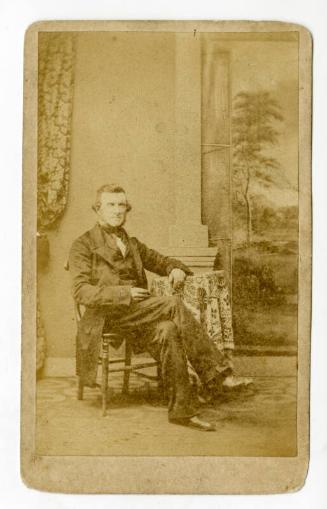 Seated man with landscape and curtain in background