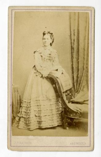 Fashionable young woman, leaning on a long chair