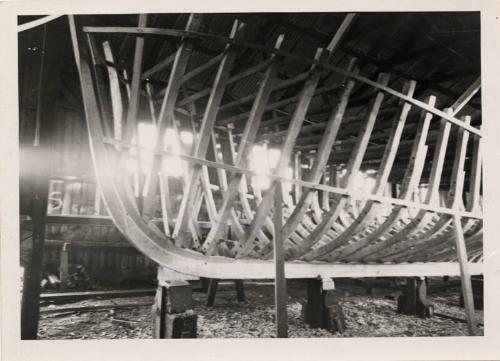 black and white photograph of cabin cruiser under construction