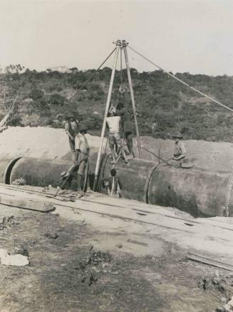 91. Quando Dam. Lowering a section of the pipe line into position