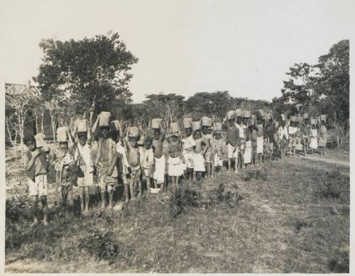 126. [Dondi] Mission. Native boys carrying 'dobies' for building a house