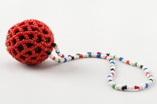 Small spherical object covered in beads with neck strap