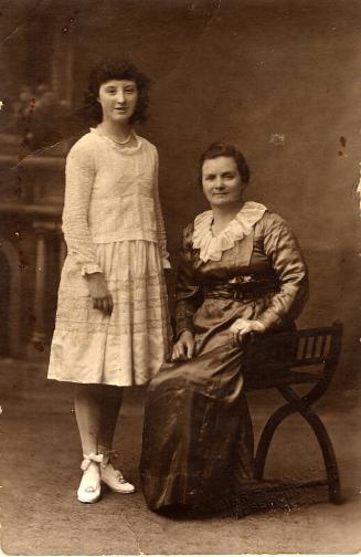 Portrait Postcard: Seated older woman with young girl stood by side 