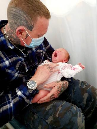 Dad holding baby for the first time when he was allowed back in hospital the next day