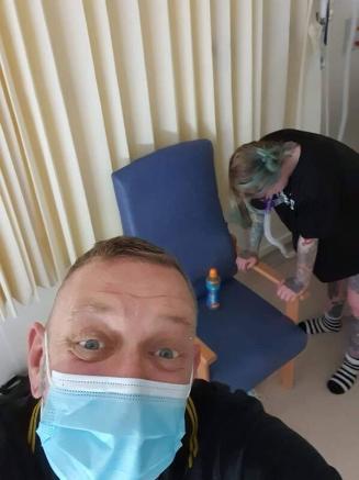 Selfie of dad with mum in labour in background