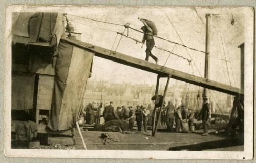 Black and white photograph showing a Man Carrying Coal Aboard Spray