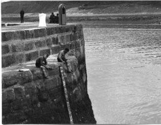 Black and white photograph showing Aberdeen Harbour in the 1930s, boys on the quayside