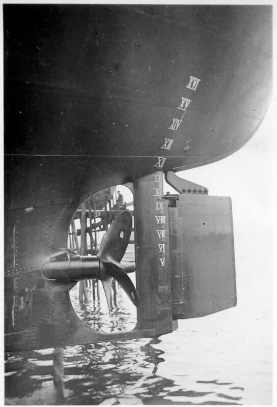 Black and White Photograph in album of close up of propeller and rudder of vessel up on stocks