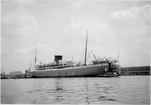 Black and White Photograph in album of ship 'Athlone Castle' being maneuvered by tugs in harbour