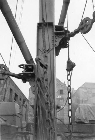 Black and White Photograph in album showing close up of lifting derricks