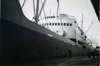 Black and White Photograph in album of cargo ship docked