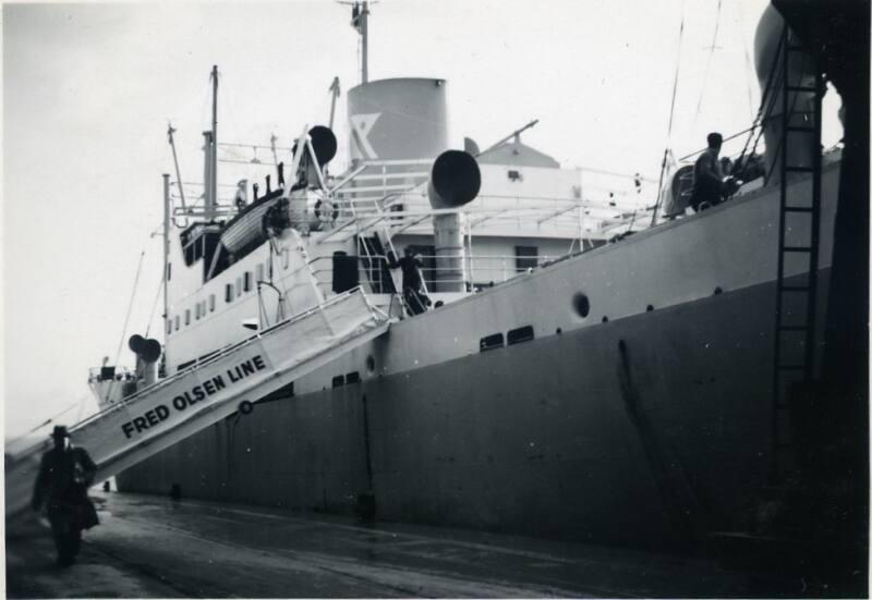 Black and White Photograph in album of cargo ship docked with Fred Olsen Line gangway