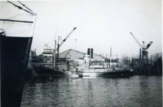 Black and White Photograph in album of ships alongside Hall Russell's shipyard