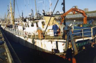 Colour Photograph Showing An Unidentified Fishing Vessel In Harbour, Looking From Stern, Crew On Deck