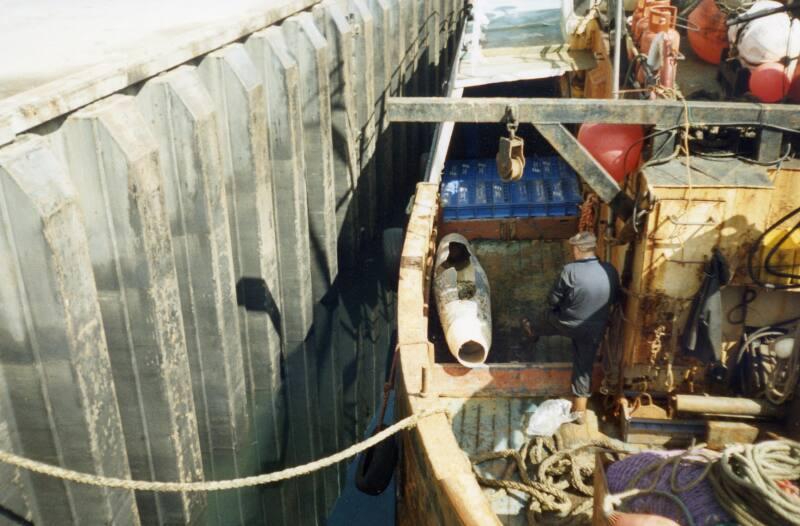 Colour Photograph Showing The Deck Of A Small Fishing Vessel Tied Up At The Quayside