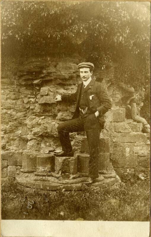 Man posing beside wall