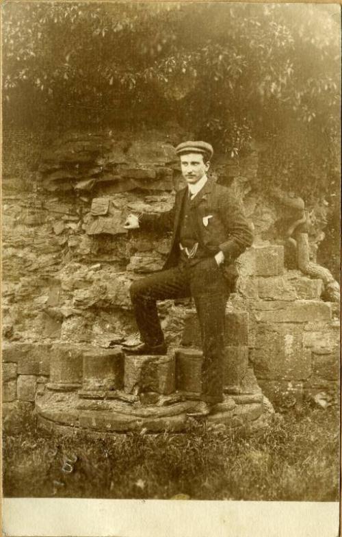 Man posing beside wall